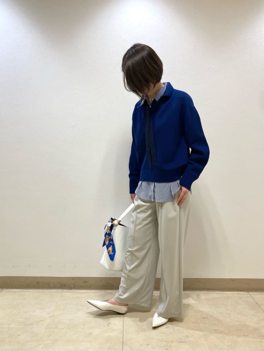 ブルー系のニット/セーター、ベージュ系のその他パンツ、ホワイト系のパンプスを着用したレディースの冬コーディネートの4枚目の写真