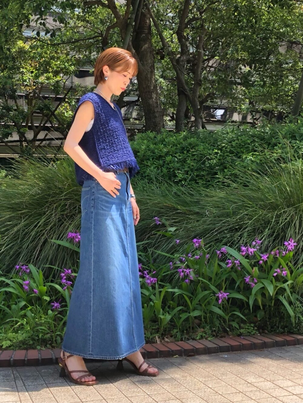 グレー系のスカート、ブルー系のニット/セーター、ブラウン系のベルトを着用したレディースの春コーディネートの3枚目の写真