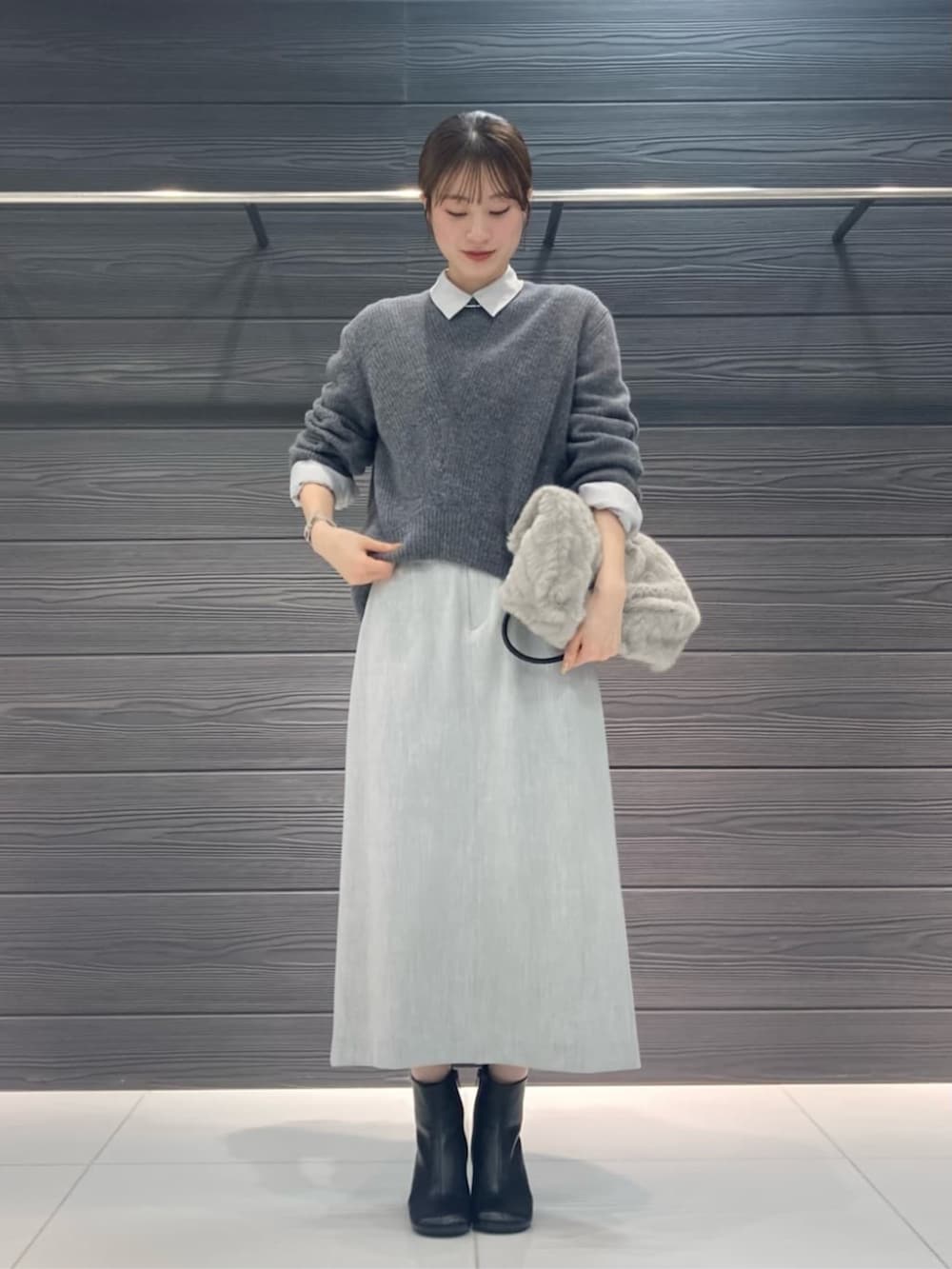 ブルー系のトレンチコート、グレー系のスカート、グレー系のニット/セーターを着用したレディースの冬コーディネートの6枚目の写真