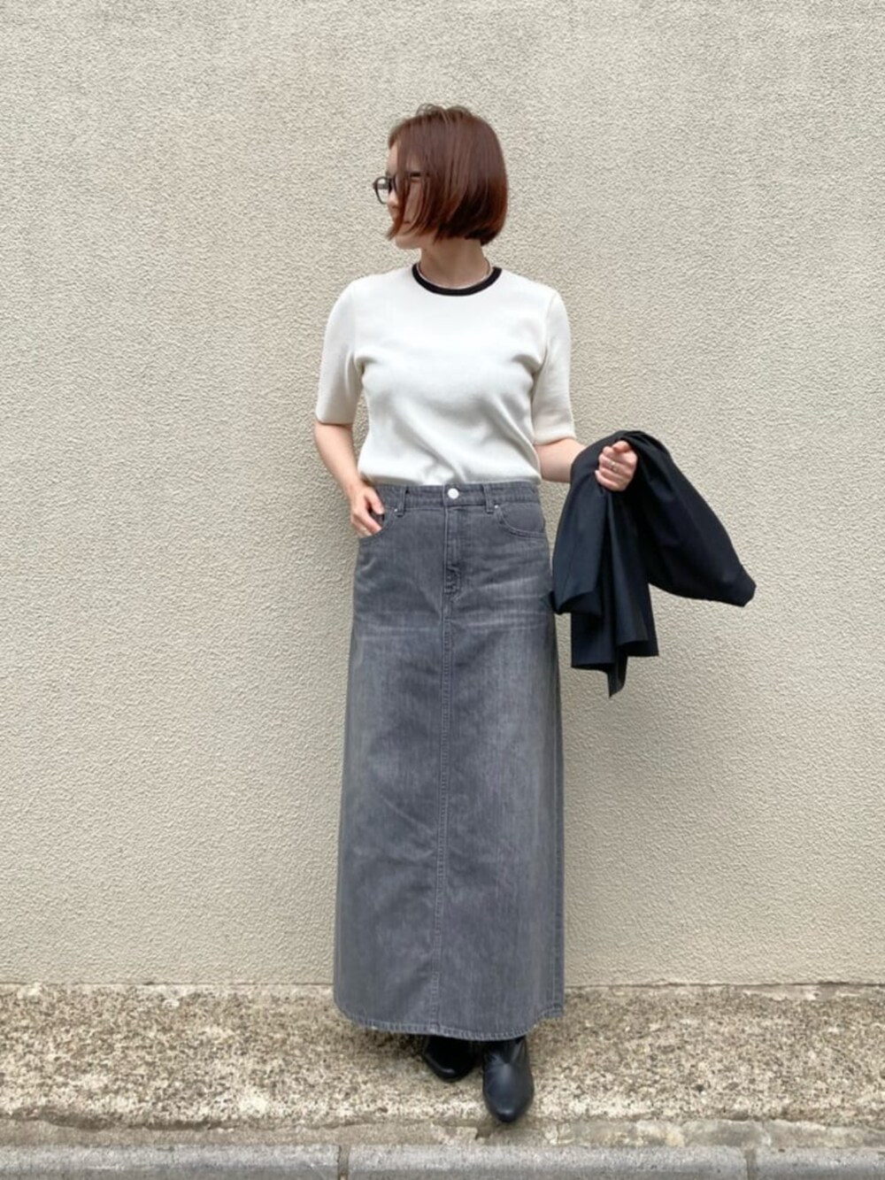 ホワイト系のニット/セーター、ブラック系のカーディガン/ボレロ、グレー系のスカートを着用したレディースの秋コーディネートの8枚目の写真