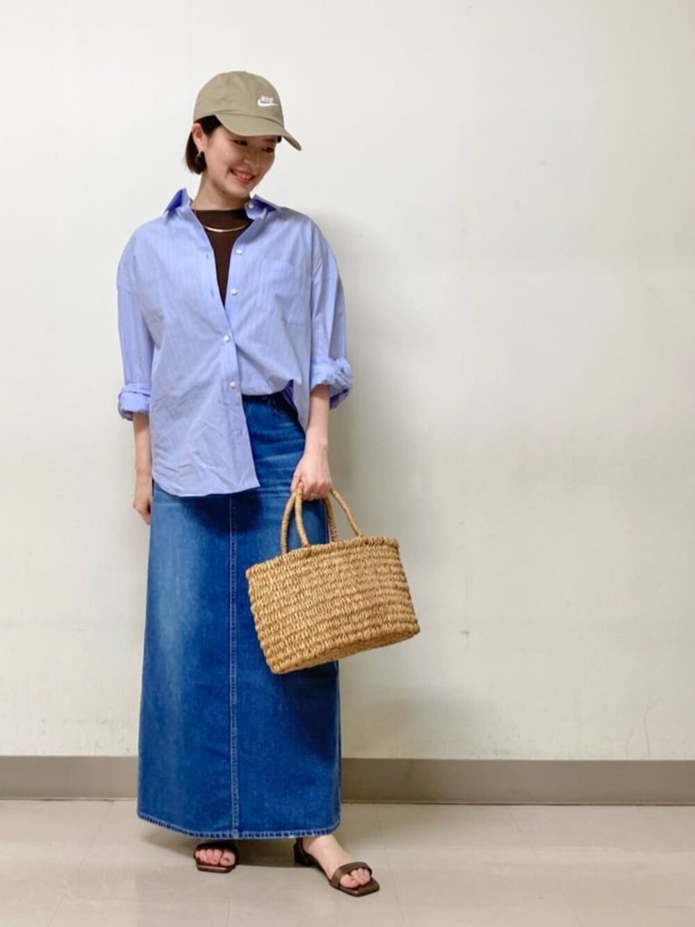 ブルー系のシャツ/ブラウス、グレー系のスカート、ブラウン系のTシャツ/カットソーを着用したレディースの夏コーディネートの2枚目の写真