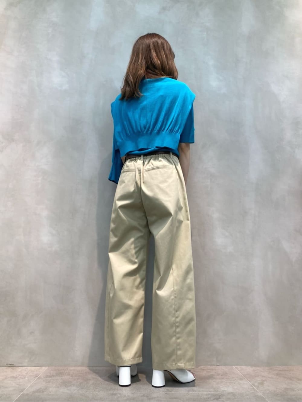 ベージュ系のチノパンツ、ホワイト系のサンダル、グリーン系のニット/セーターを着用したレディースの夏コーディネートの5枚目の写真