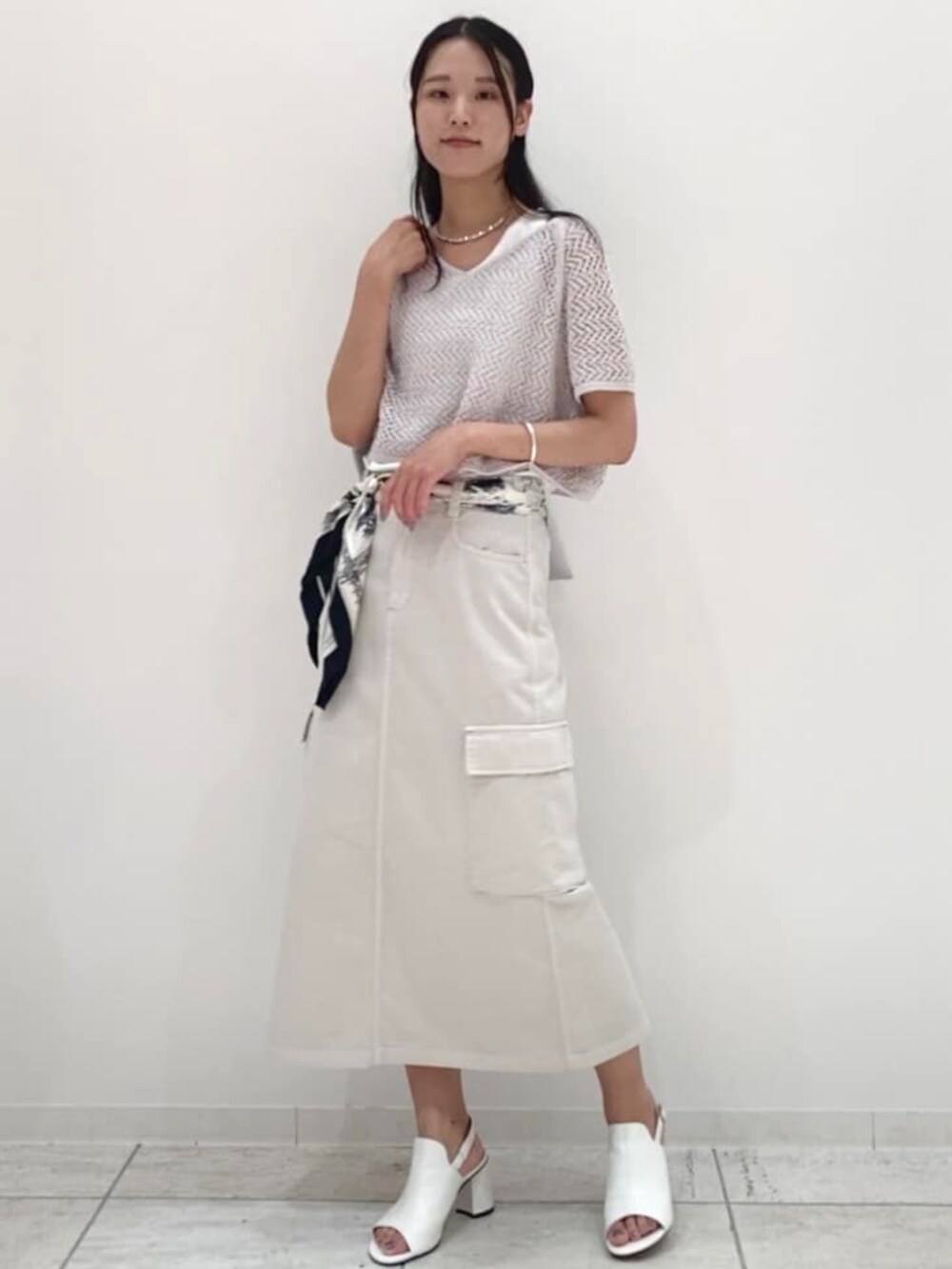 ホワイト系のサンダル、グレー系のアンサンブル、シルバー系のトートバッグを着用したレディースの夏コーディネートの2枚目の写真