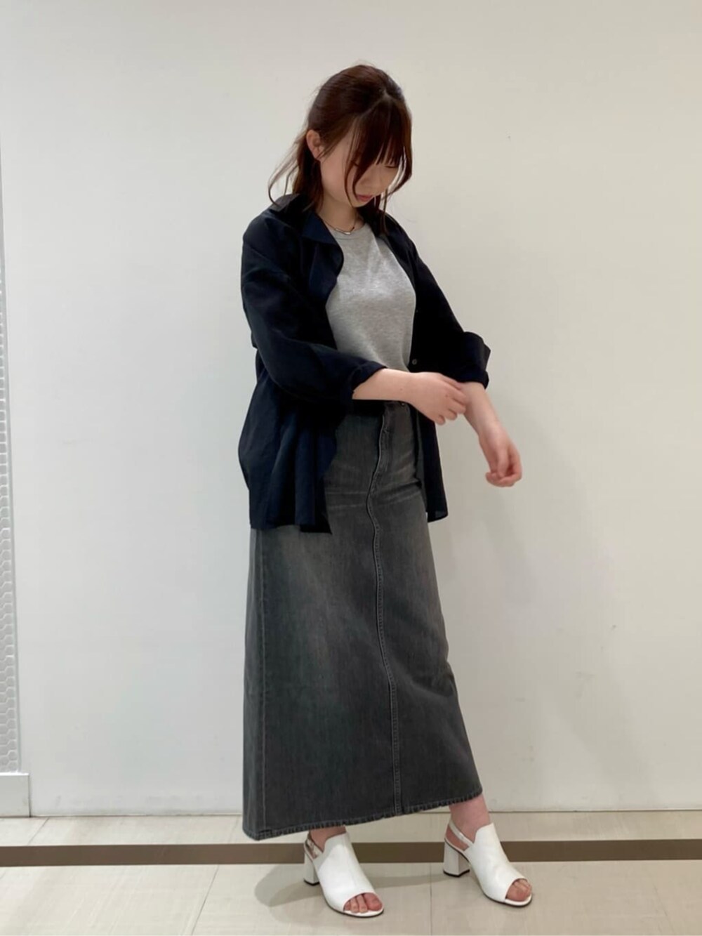 ホワイト系のサンダル、ブラック系のシャツ/ブラウス、グレー系のスカートを着用したレディースの春コーディネートの3枚目の写真