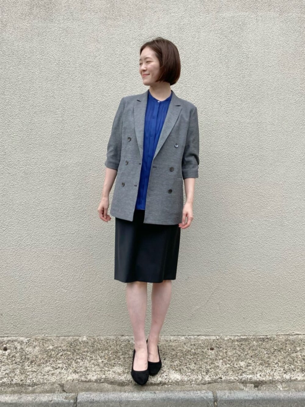 ブルー系のシャツ/ブラウス、グレー系のテーラードジャケット、ブラック系のスーツスカートを着用したレディースの秋コーディネートの2枚目の写真