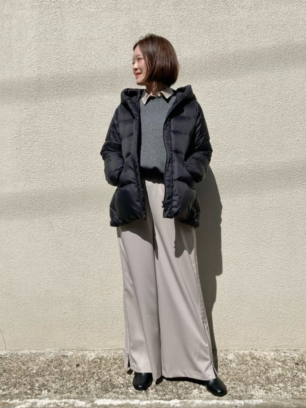 ブラック系のダウンジャケット/コート、ベージュ系のその他パンツ、グレー系のTシャツ/カットソーを着用したレディースの冬コーディネートの3枚目の写真