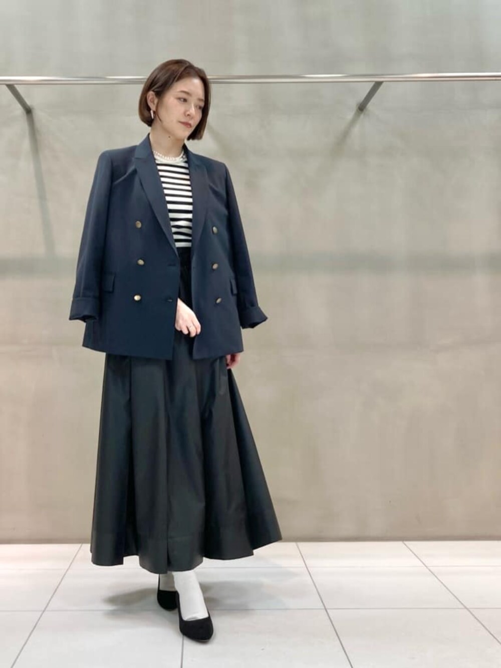 ブルー系のセットアップ、ホワイト系のニット/セーター、ブラック系のスカートを着用したレディースの春コーディネートの5枚目の写真