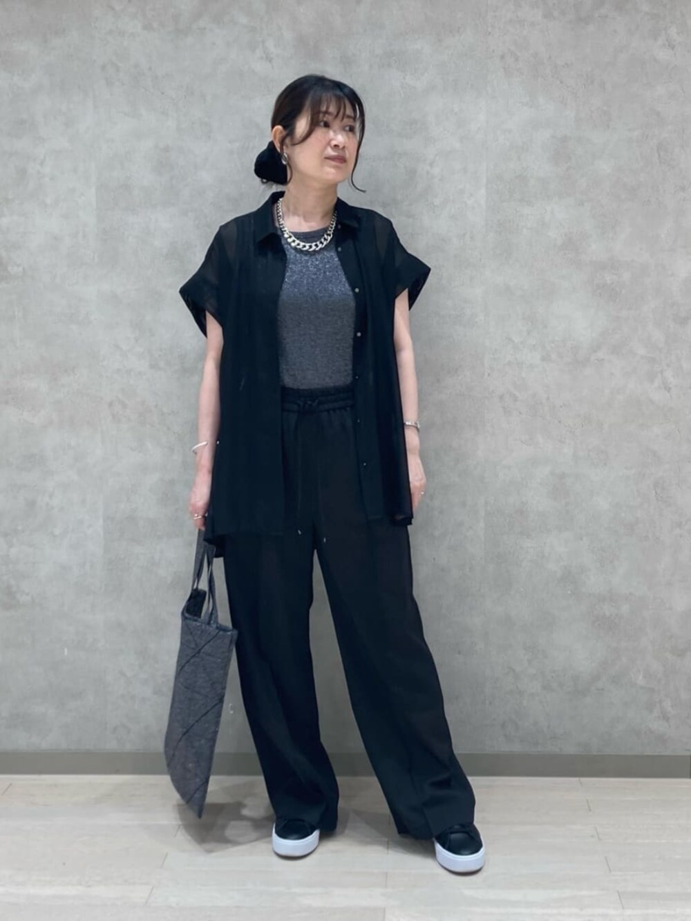 ブラック系のシャツ/ブラウス、グレー系のタンクトップ、ブラック系のスラックスを着用したレディースの夏コーディネートの2枚目の写真