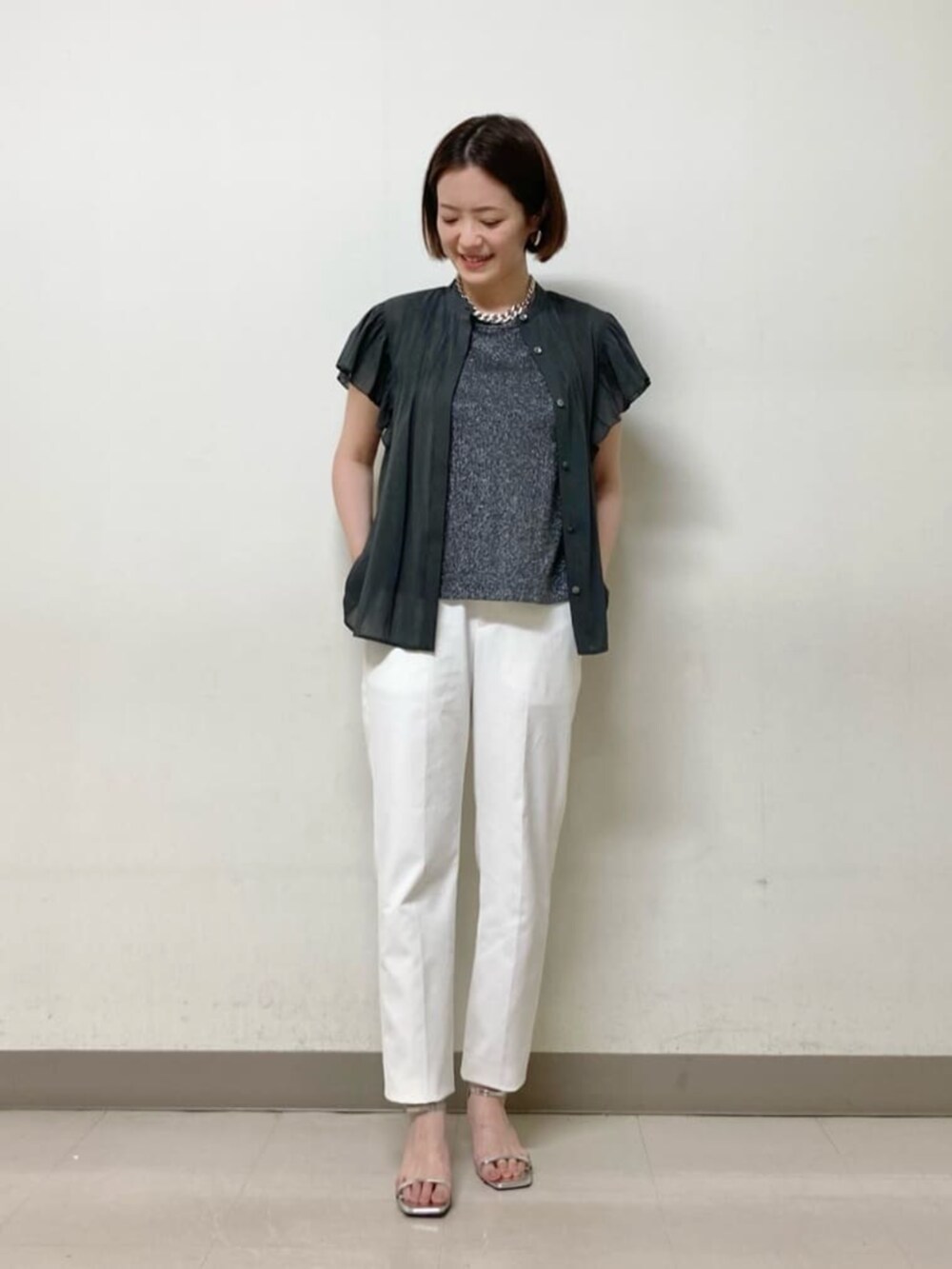 ベージュ系のカーディガン/ボレロ、グレー系のシャツ/ブラウス、ホワイト系のパンツを着用したレディースの夏コーディネートの5枚目の写真