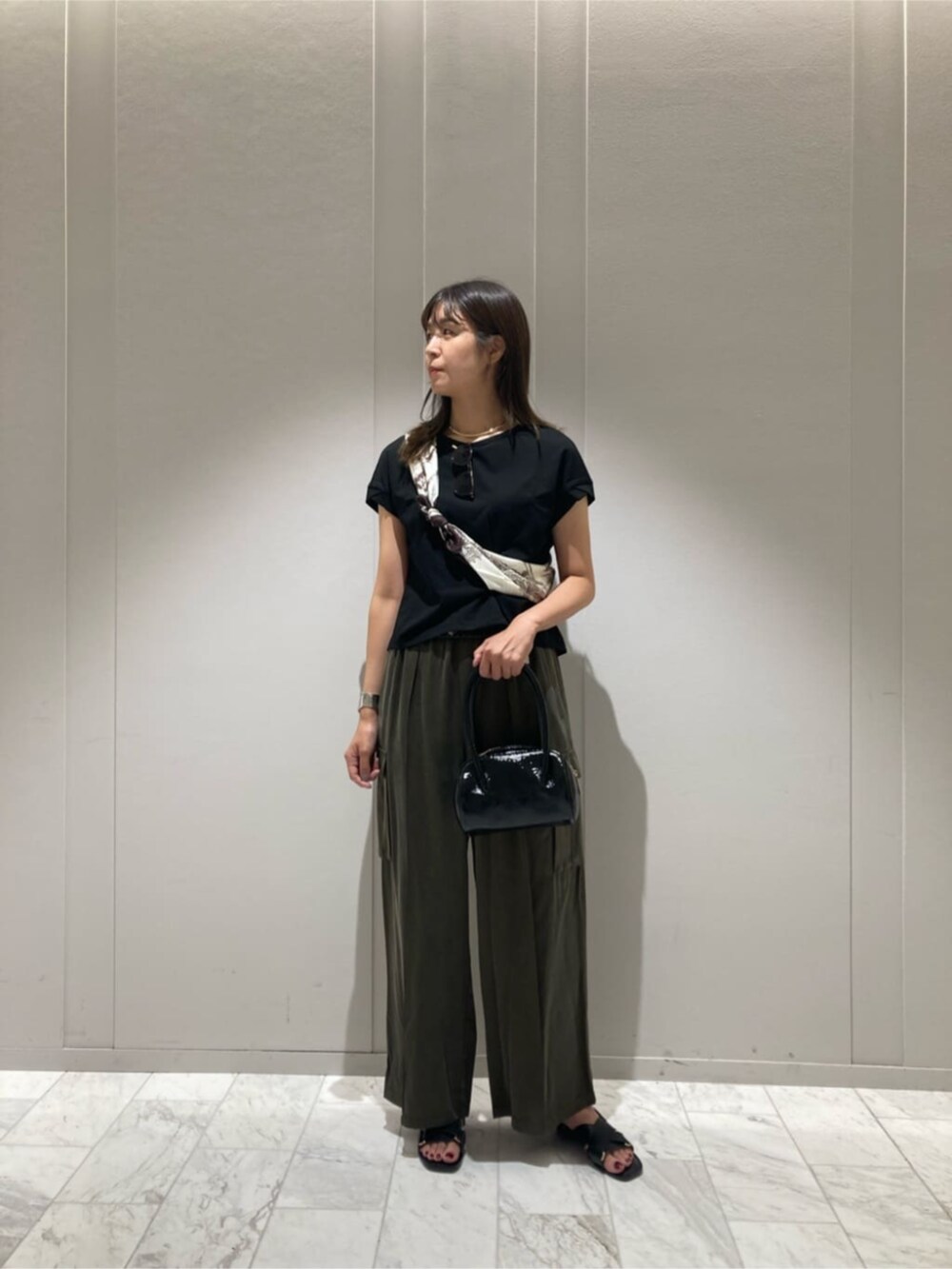 グリーン系のその他パンツ、ブラック系のTシャツ/カットソー、ブラウン系のストール/ショールを着用したレディースの秋コーディネートの3枚目の写真