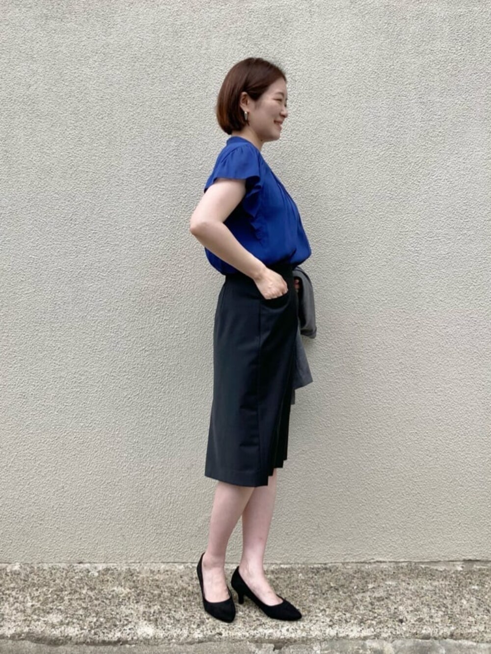 ブルー系のシャツ/ブラウス、グレー系のテーラードジャケット、ブラック系のスーツスカートを着用したレディースの秋コーディネートの5枚目の写真