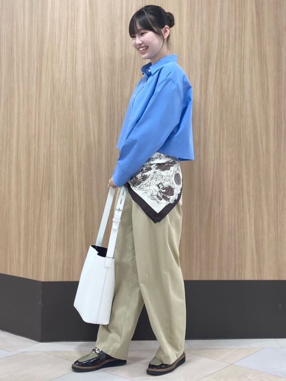 ブルー系のシャツ/ブラウス、グレー系のチノパンツ、ブラウン系のストール/ショールを着用したレディースの夏コーディネートの2枚目の写真