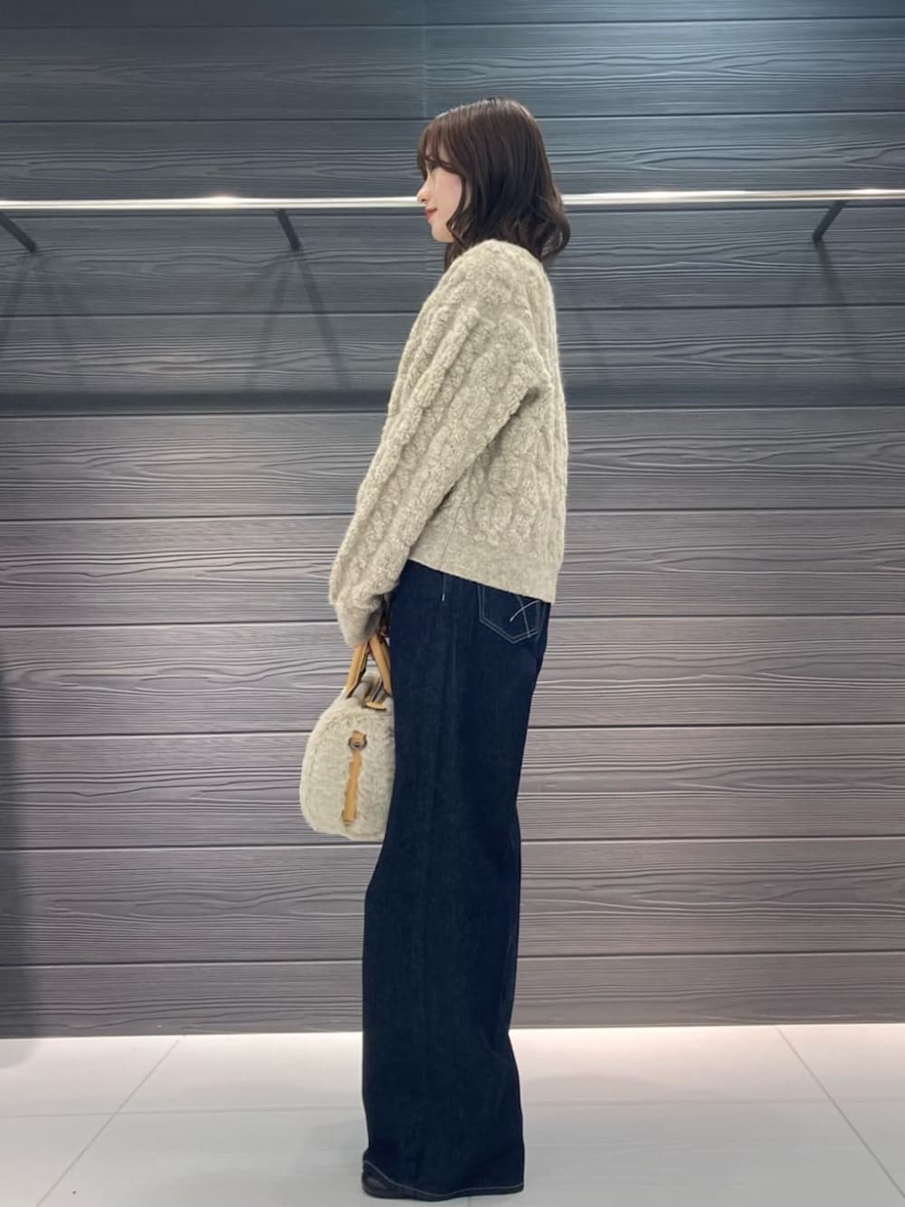 ブルー系のデニムパンツ、ブラック系のブーツ、ベージュ系のカーディガン/ボレロを着用したレディースの冬コーディネートの3枚目の写真