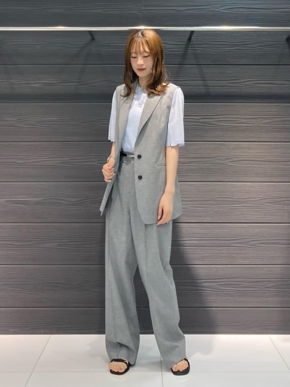 ブラック系のベスト、ブラック系のその他パンツ、ブルー系のニット/セーターを着用したレディースの春コーディネートの2枚目の写真