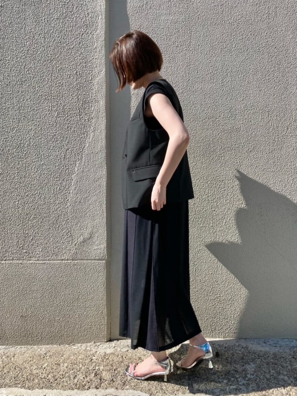 ブラック系のベストを着用したレディースの夏コーディネートの4枚目の写真