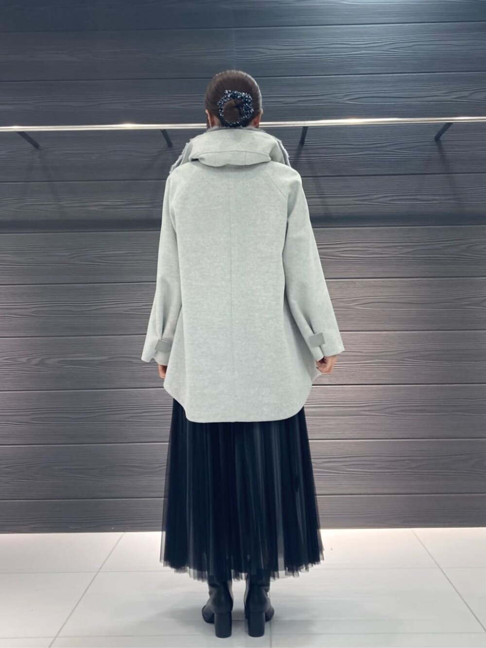 グレー系のスカート、グレー系のその他アウター、ブルー系のニット/セーターを着用したレディースの秋コーディネートの3枚目の写真