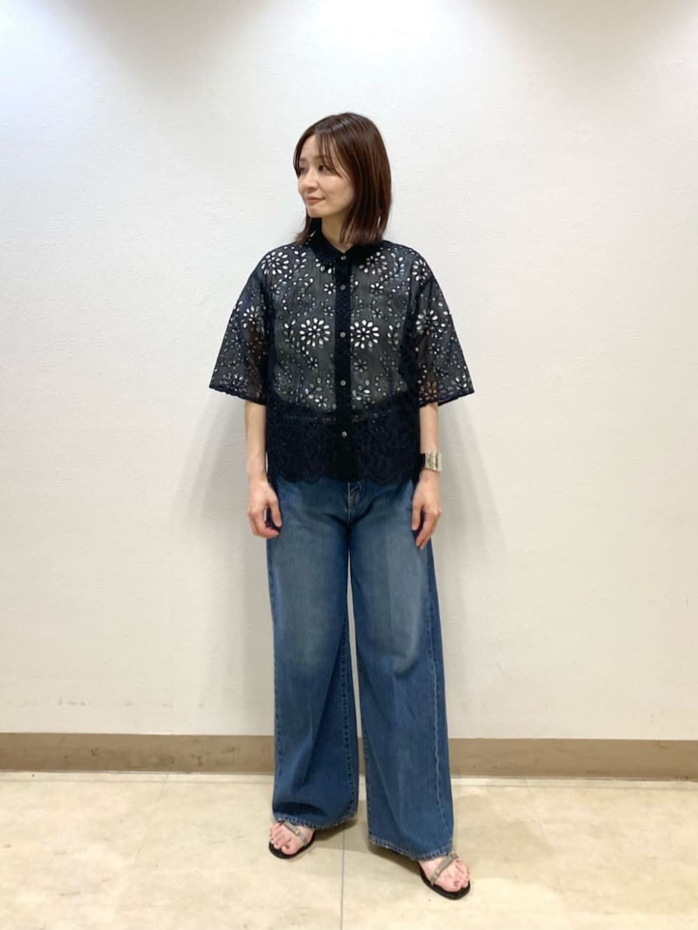 ブルー系のデニムパンツ、ブラック系のシャツ/ブラウス、グレー系のサンダルを着用したレディースの春コーディネートの3枚目の写真