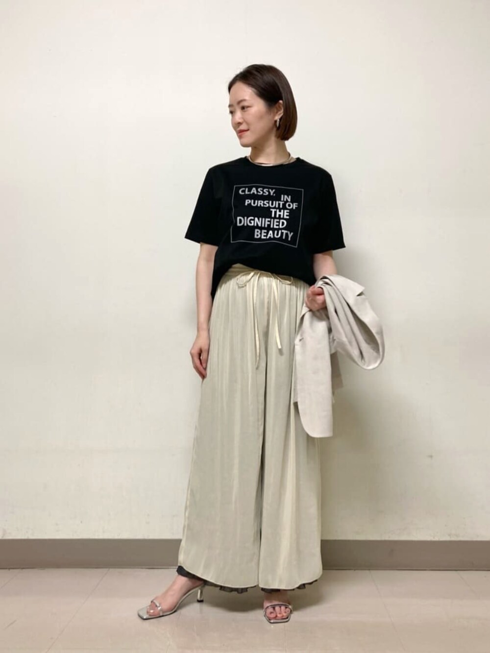ベージュ系のテーラードジャケット、グレー系のその他パンツ、ブラック系のTシャツ/カットソーを着用したレディースの春コーディネートの4枚目の写真