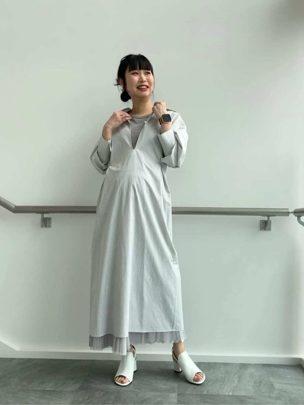 グレー系のスカート、ホワイト系のサンダル、グレー系のシャツワンピースを着用したレディースの春コーディネートの2枚目の写真