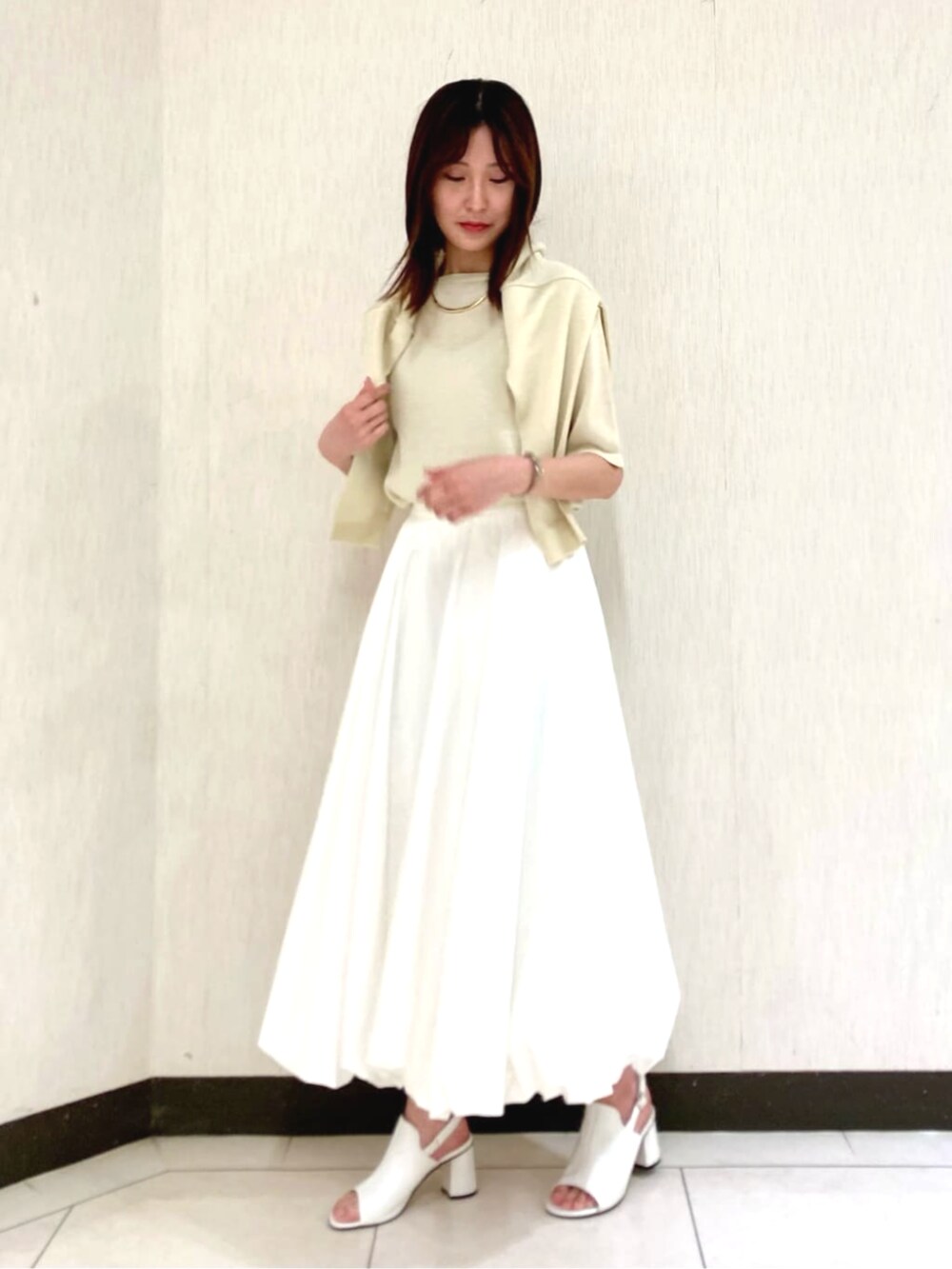 ホワイト系のスカート、イエロー系のカーディガン/ボレロ、イエロー系のニット/セーターを着用したレディースの春コーディネートの4枚目の写真