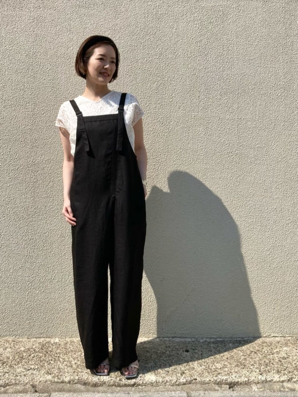 ホワイト系のシャツ/ブラウス、ブラック系のオールインワン・サロペットを着用したレディースの春コーディネートの4枚目の写真