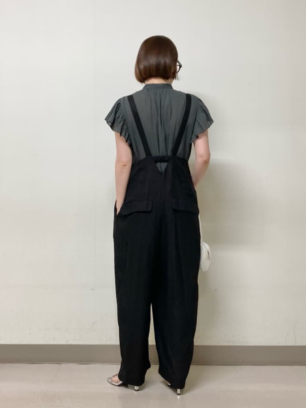 グレー系のシャツ/ブラウス、ブラック系のオールインワン・サロペット、ホワイト系のバッグを着用したレディースの夏コーディネートの5枚目の写真