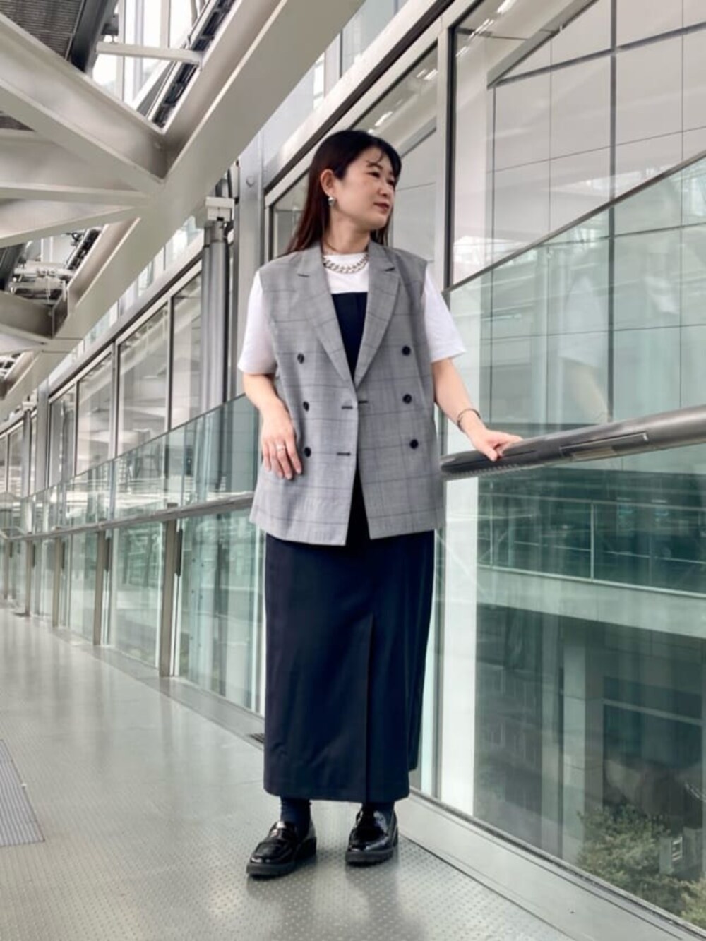 ブラック系のその他シューズ、ブラック系のベスト、ホワイト系のTシャツ/カットソーを着用したレディースの夏コーディネートの3枚目の写真