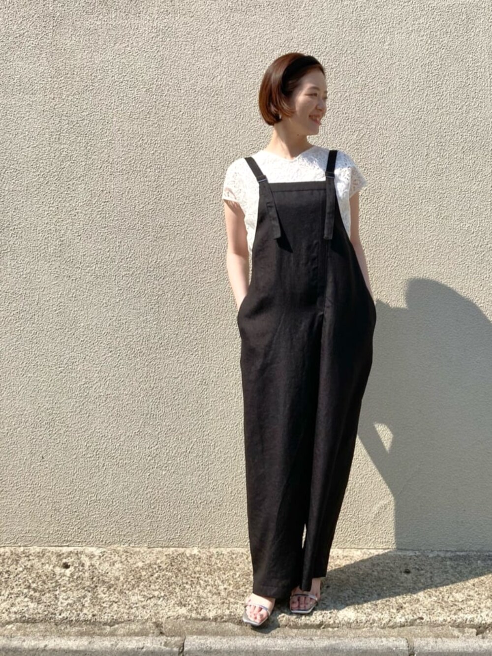 ホワイト系のシャツ/ブラウス、ブラック系のオールインワン・サロペットを着用したレディースの春コーディネートの6枚目の写真