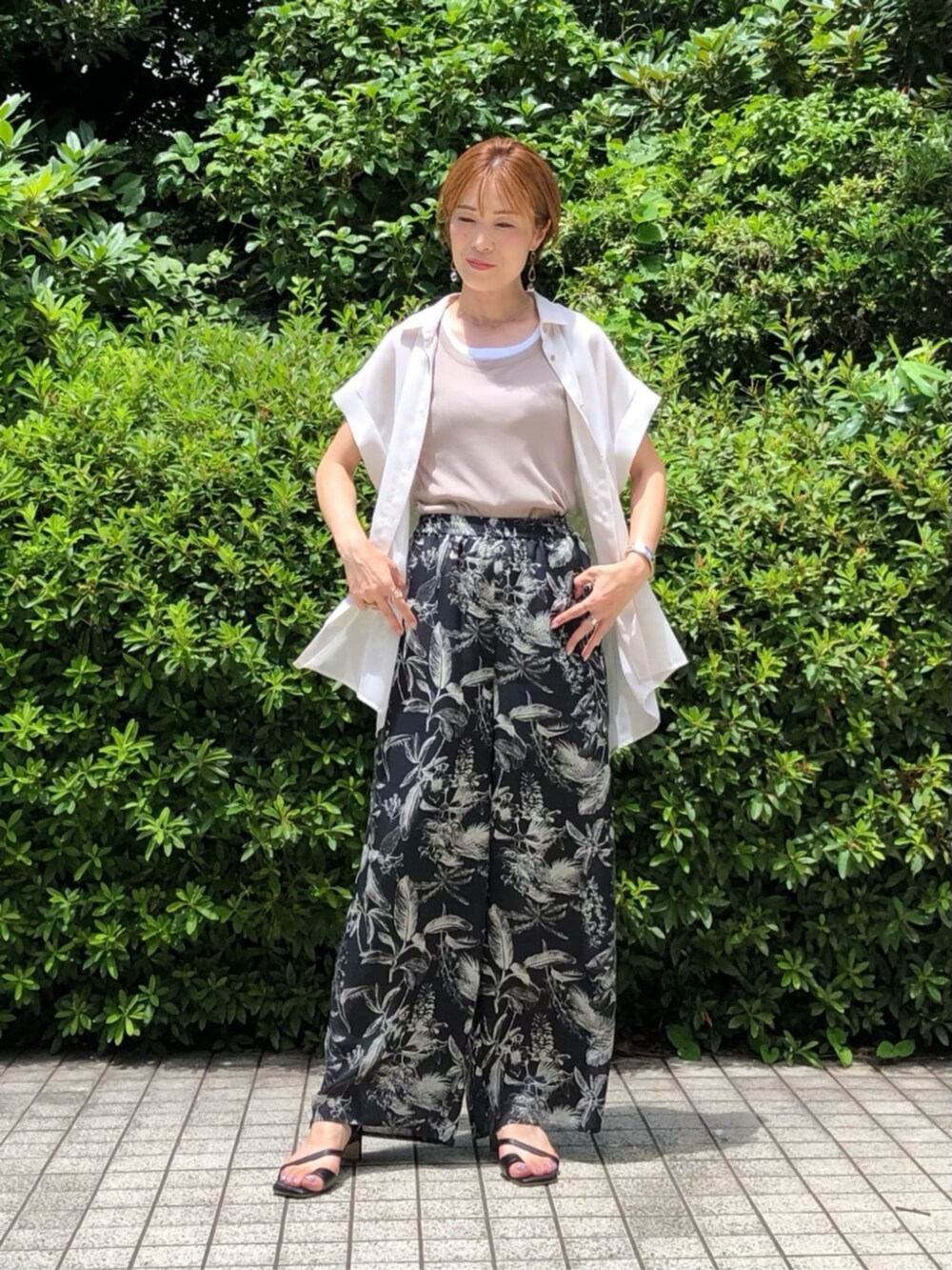 ベージュ系のタンクトップ、ホワイト系のシャツ/ブラウス、ブラック系のパンツを着用したレディースの夏コーディネートの3枚目の写真