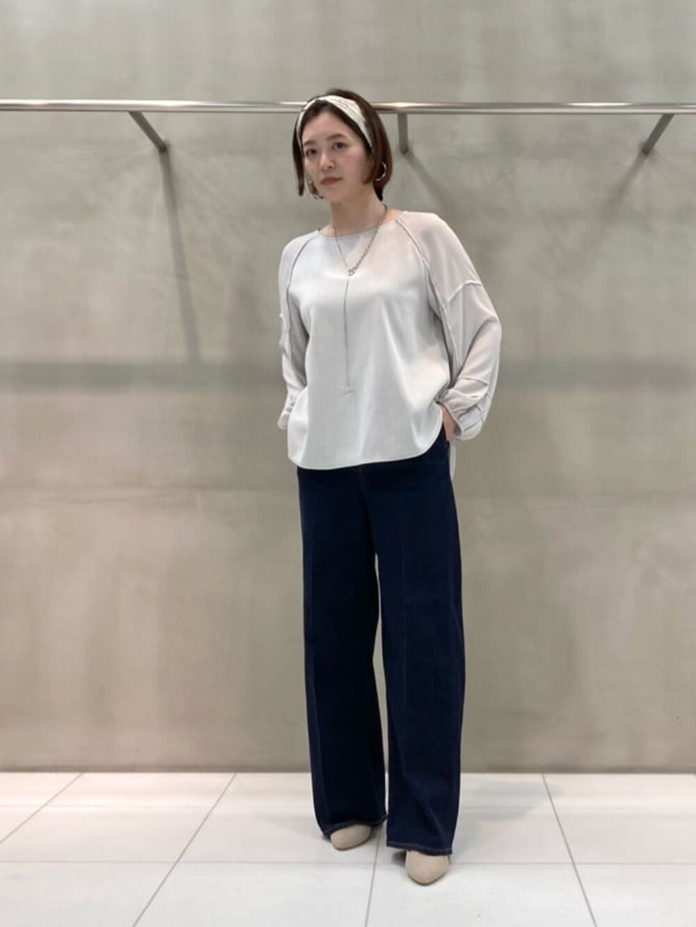 ブルー系のデニムパンツ、グレー系のシャツ/ブラウス、ブラウン系のストール/ショールを着用したレディースの春コーディネートの2枚目の写真