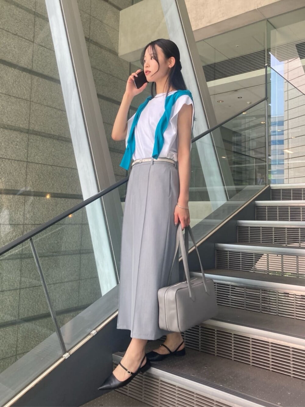 グレー系のスカート、グリーン系のカーディガン/ボレロ、ホワイト系のTシャツ/カットソーを着用したレディースの夏コーディネートの2枚目の写真