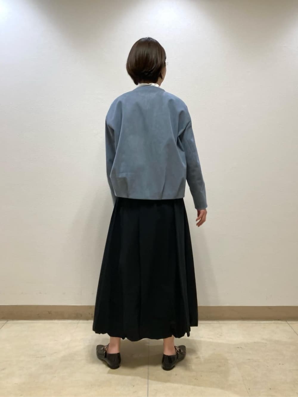 ブラック系のスカート、ブラック系のパンプス、ブルー系のブルゾンを着用したレディースの冬コーディネートの4枚目の写真