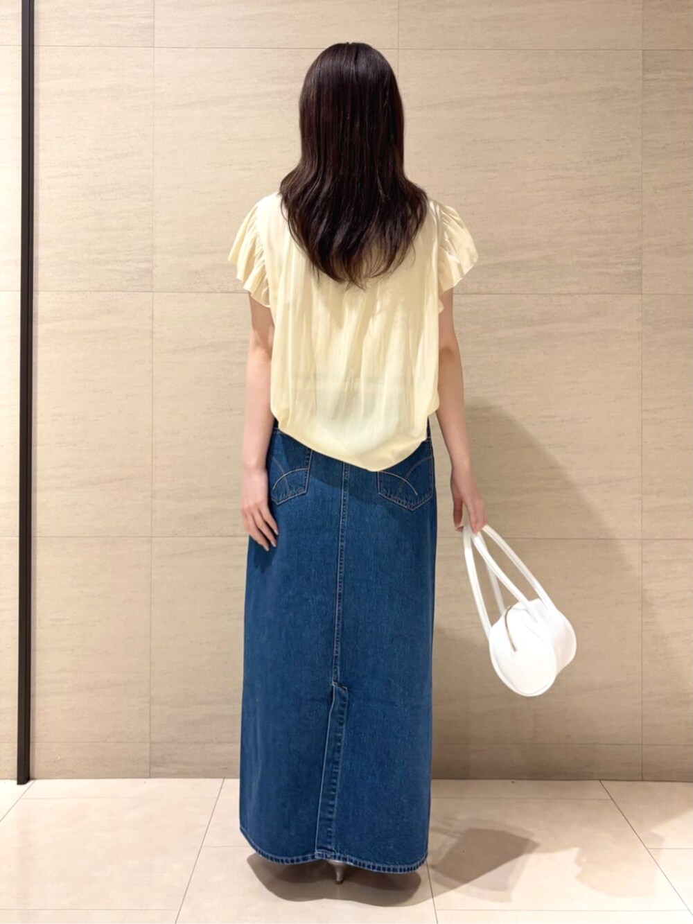 イエロー系のシャツ/ブラウス、グレー系のスカートを着用したレディースの夏コーディネートの2枚目の写真