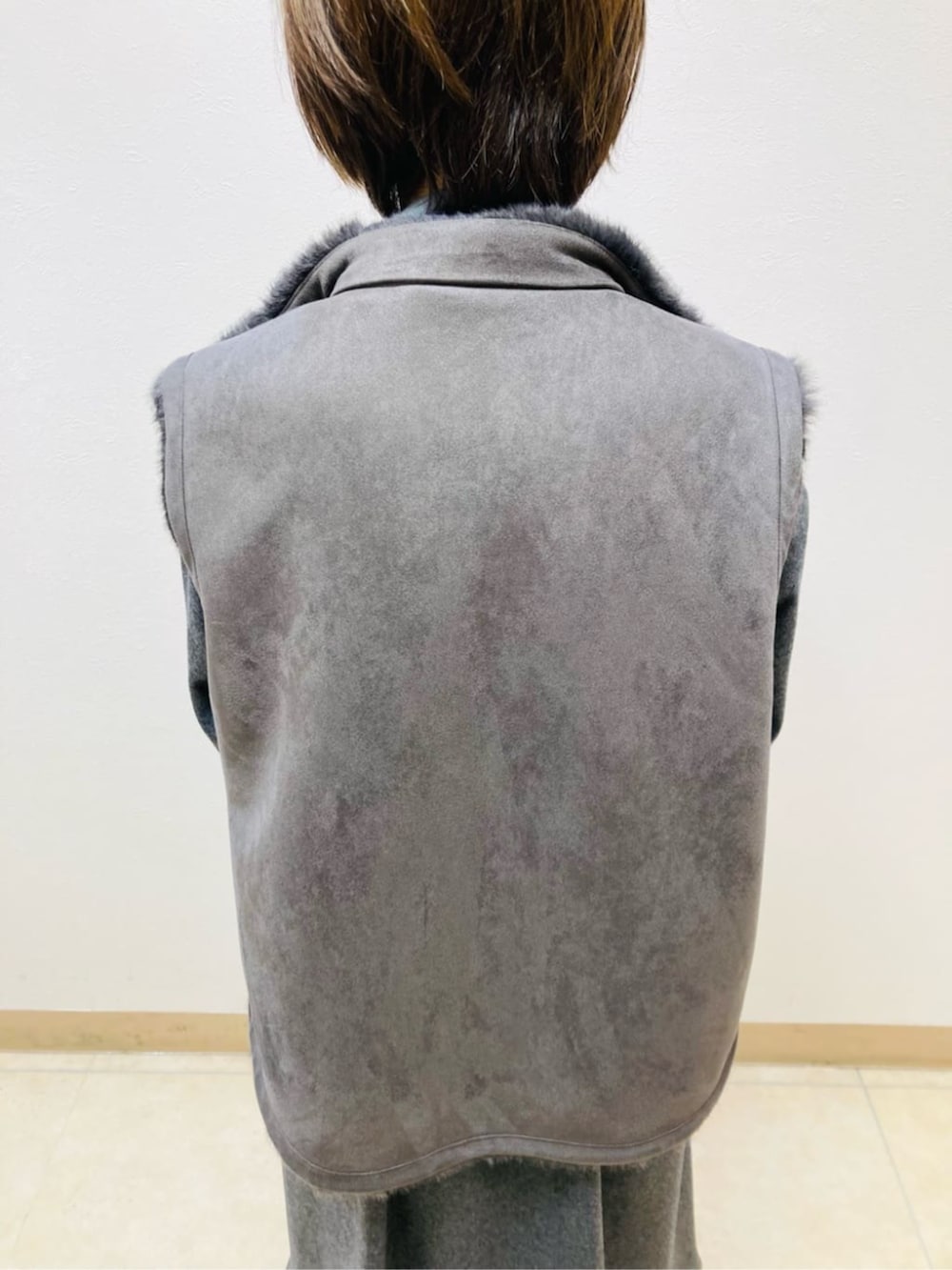 グレー系のベスト、グレー系のワンピースを着用したレディースの秋コーディネートの6枚目の写真