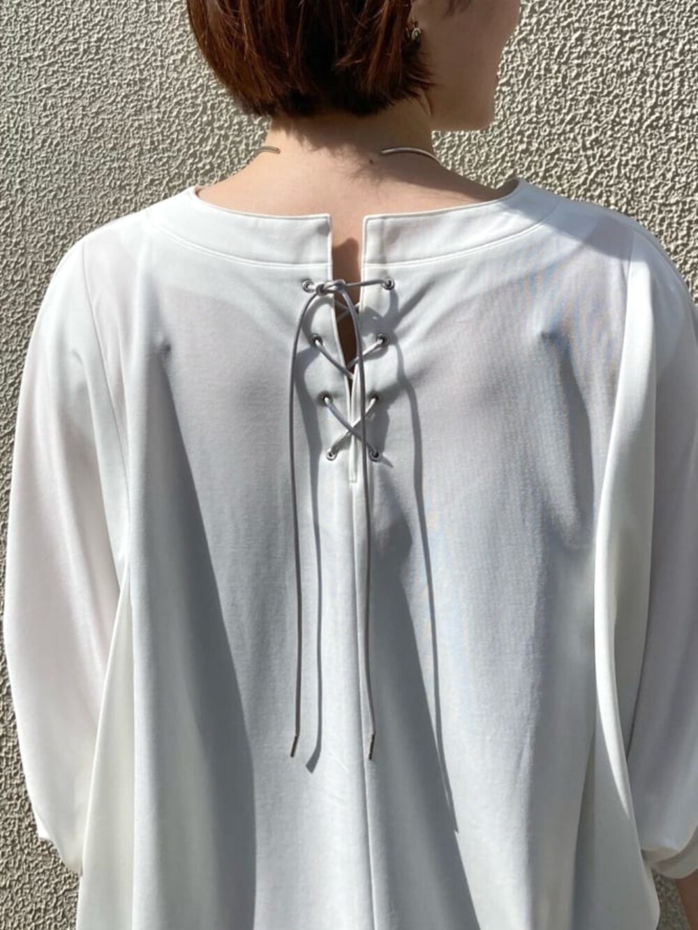 グリーン系のパンツ、ホワイト系のトップスを着用したレディースの夏コーディネートの4枚目の写真