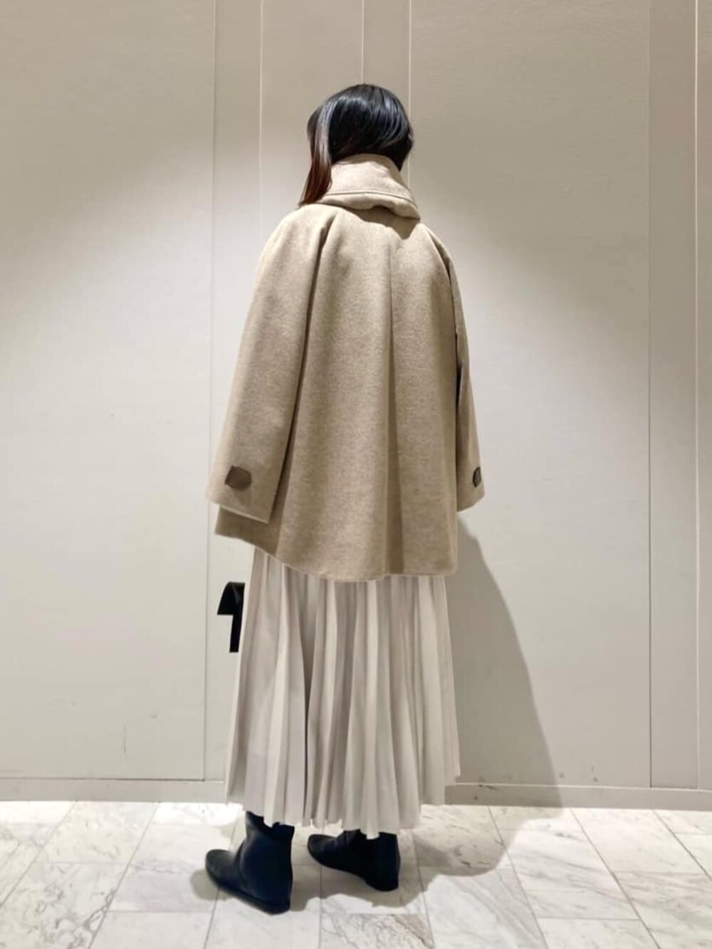 ホワイト系のスカート、ブラウン系のその他アウター、ベージュ系のニット/セーターを着用したレディースの冬コーディネートの6枚目の写真