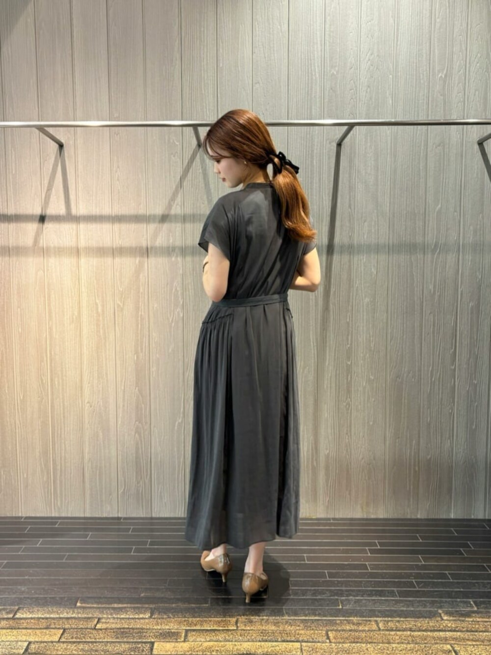 グレー系のワンピース、シルバー系のネックレスを着用したレディースの夏コーディネートの2枚目の写真