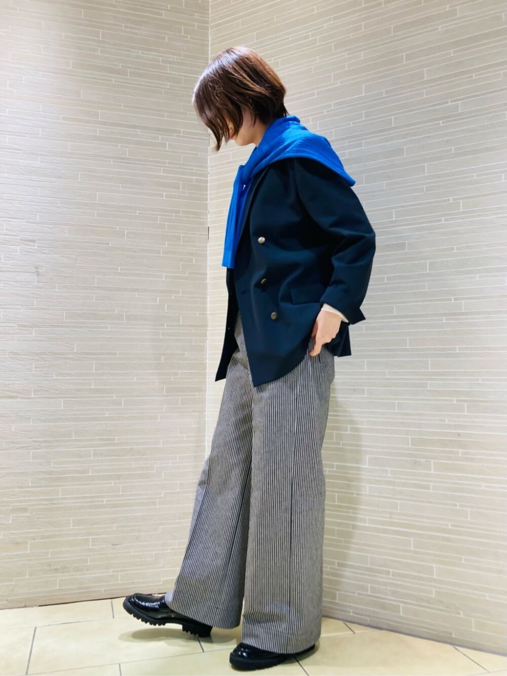 ブラック系のその他シューズ、ブルー系のテーラードジャケット、ブラック系のその他パンツを着用したレディースの秋コーディネートの2枚目の写真