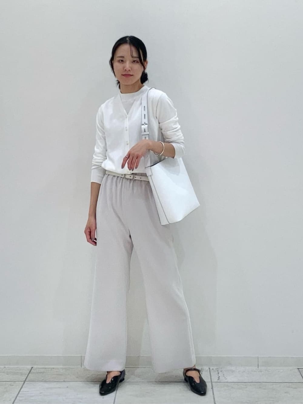 ホワイト系のその他アウター、ブラック系のその他パンツ、ホワイト系のカーディガン/ボレロを着用したレディースの冬コーディネートの2枚目の写真