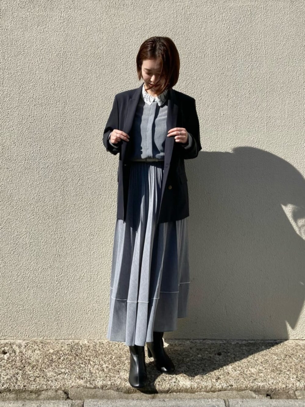 ブルー系のセットアップ、グレー系のシャツ/ブラウス、グレー系のスカートを着用したレディースの秋コーディネートの4枚目の写真