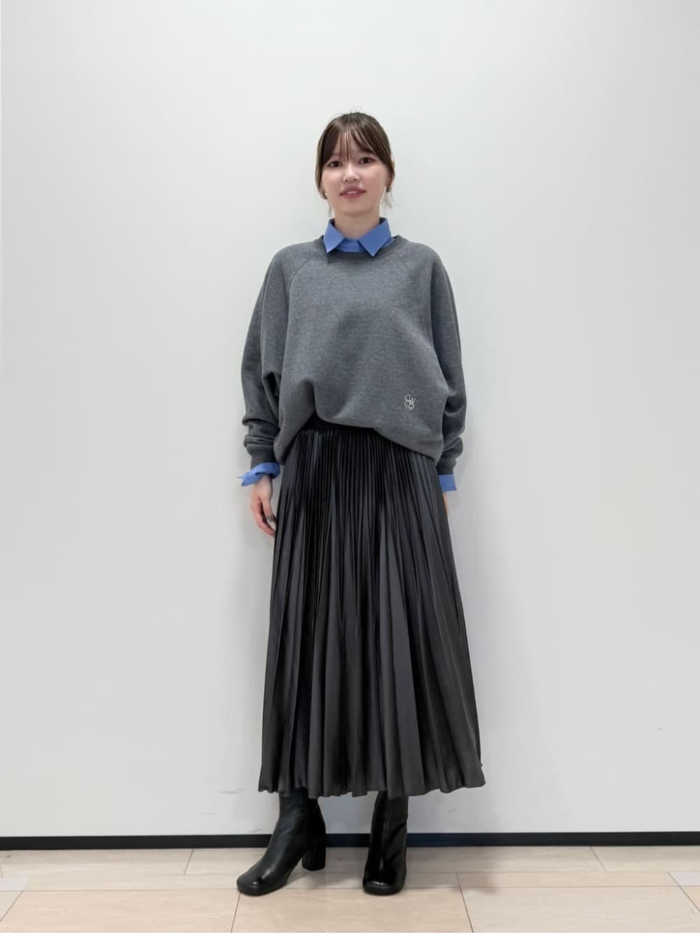 ブルー系のその他アウター、グレー系のスカート、ブラック系のブーツを着用したレディースの秋コーディネートの4枚目の写真