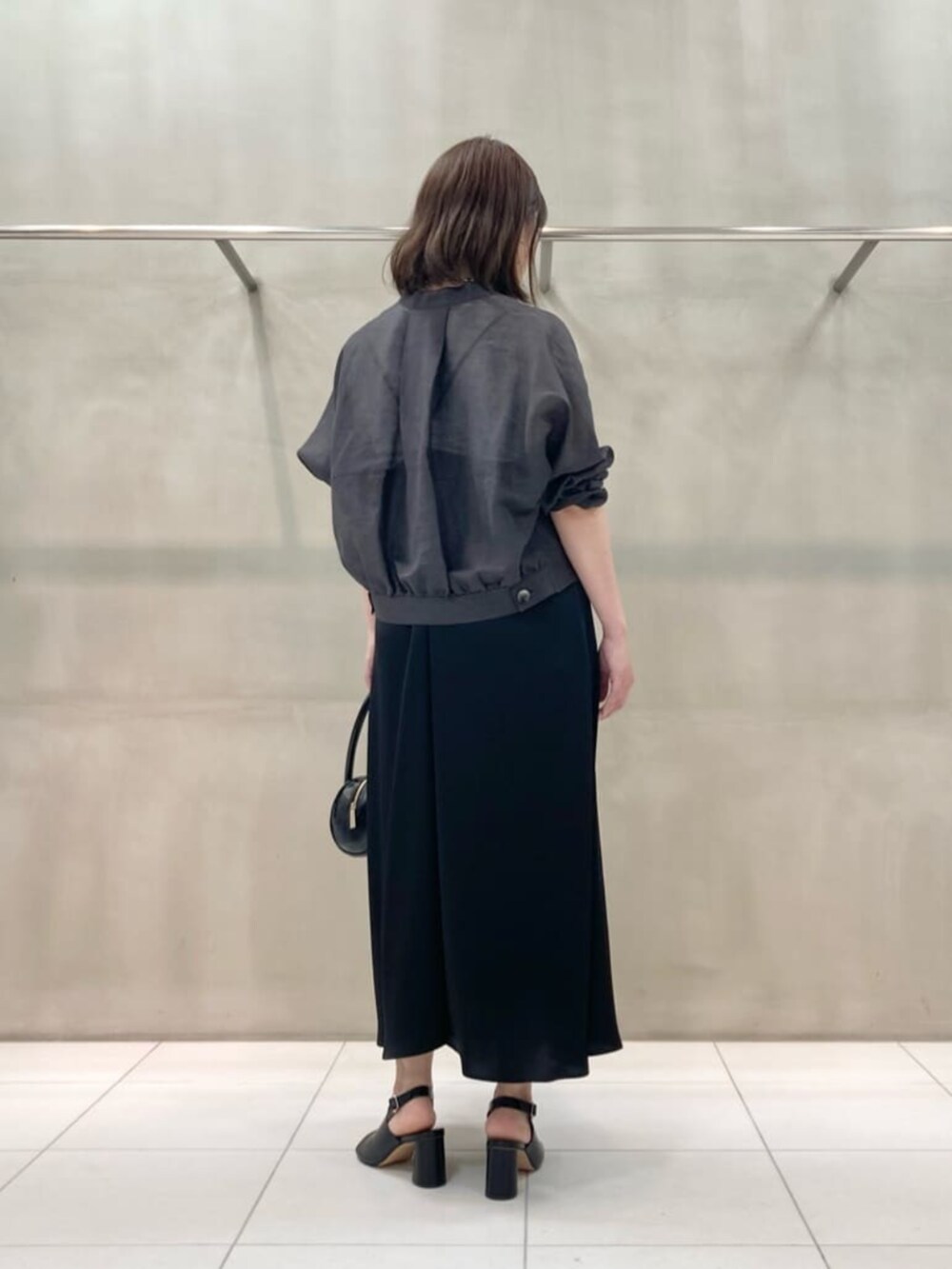 ブラック系のサンダル、ブラック系のワンピース、シルバー系のネックレスを着用したレディースの夏コーディネートの4枚目の写真