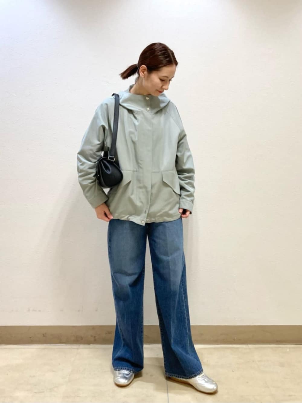 ブラック系のショルダーバッグ、グリーン系のパーカー、ピンク系のシャツ/ブラウスを着用したレディースの春コーディネートの3枚目の写真