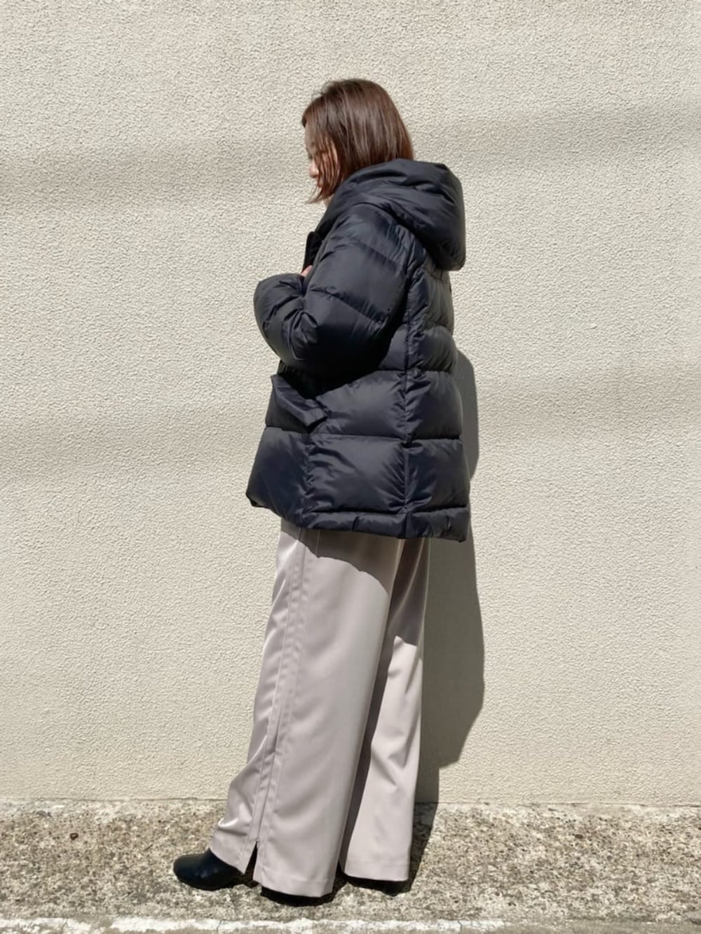 ブラック系のダウンジャケット/コート、ベージュ系のその他パンツ、グレー系のTシャツ/カットソーを着用したレディースの冬コーディネートの5枚目の写真