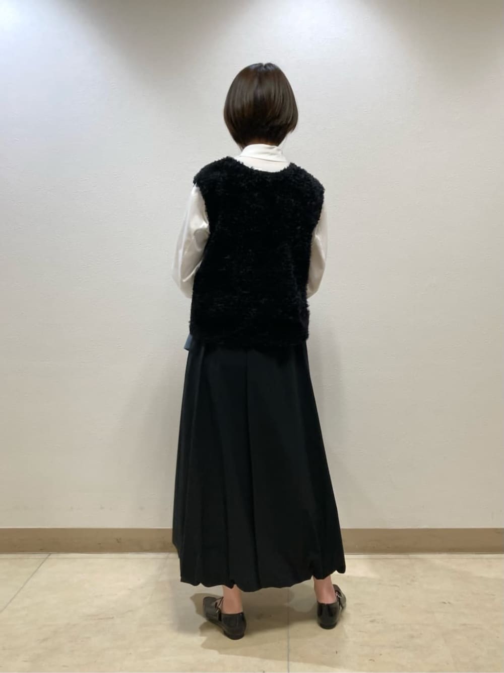 ブラック系のスカート、ブラック系のパンプス、ブルー系のブルゾンを着用したレディースの冬コーディネートの7枚目の写真