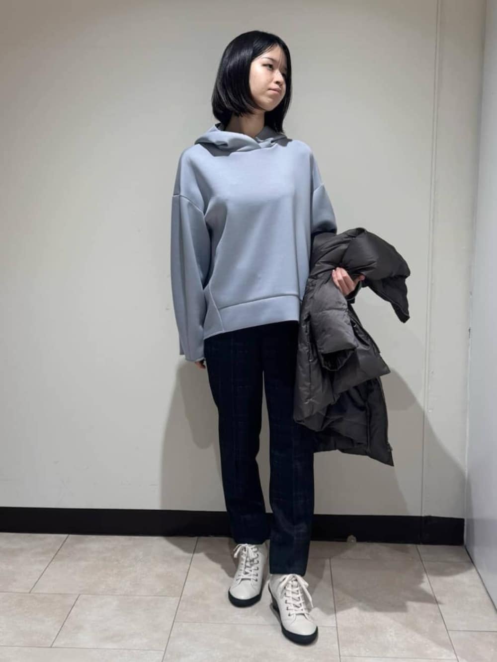 グレー系のダウンジャケット/コート、ブラウン系のその他パンツ、ブルー系のパーカーを着用したレディースの冬コーディネートの4枚目の写真