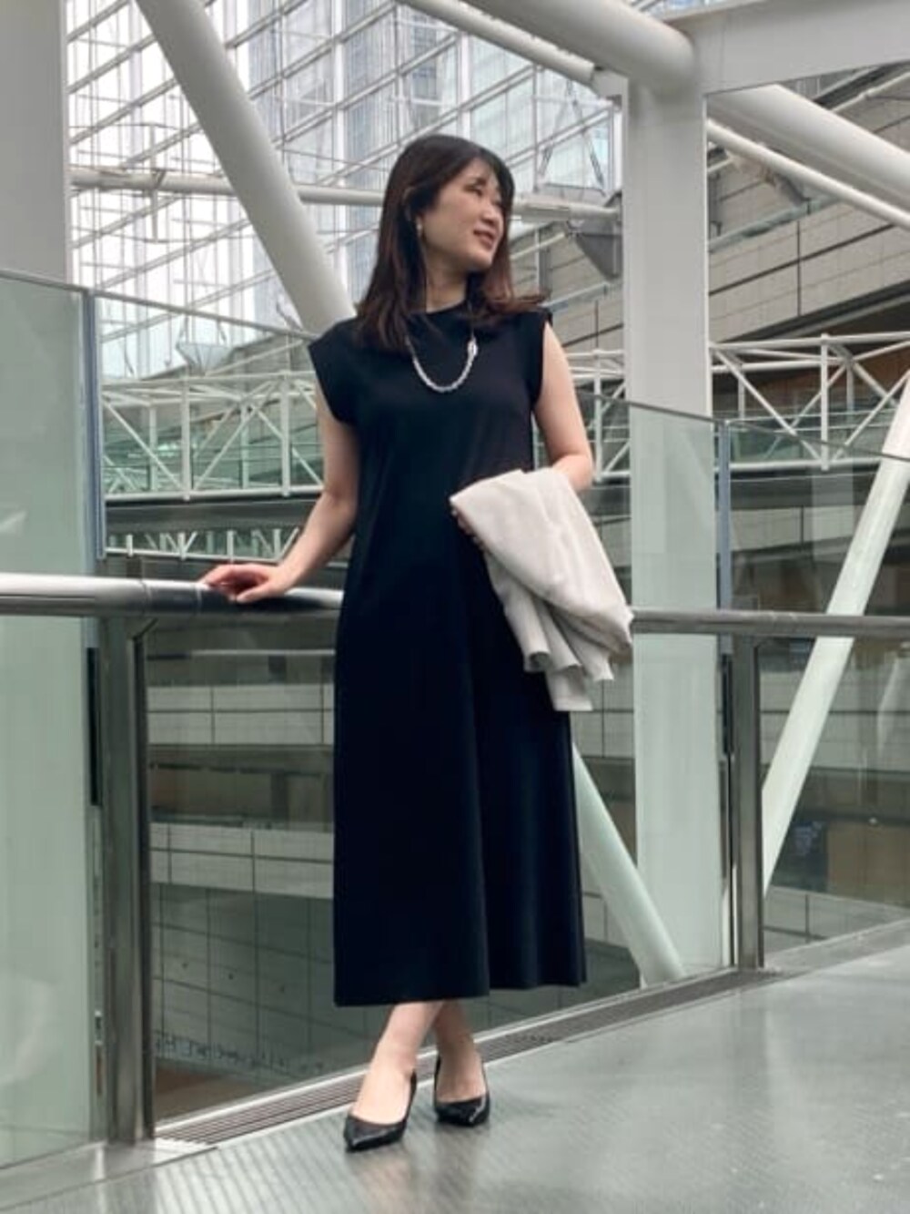 ホワイト系のノーカラージャケット、ブラック系のワンピース/ドレス、シルバー系のネックレスを着用したレディースの夏コーディネートの2枚目の写真