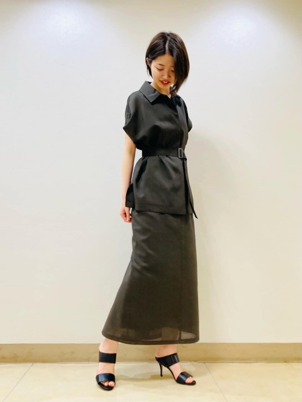 ブラウン系のベスト、ブラウン系のスカート、ゴールド系のネックレスを着用したレディースの夏コーディネートの2枚目の写真