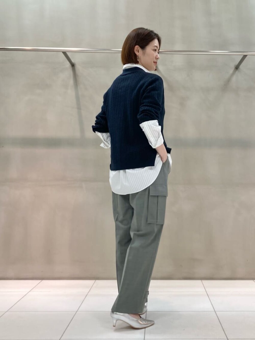 ブルー系のニット/セーター、ホワイト系のシャツ/ブラウス、グレー系のカーゴパンツを着用したレディースの夏コーディネートの3枚目の写真