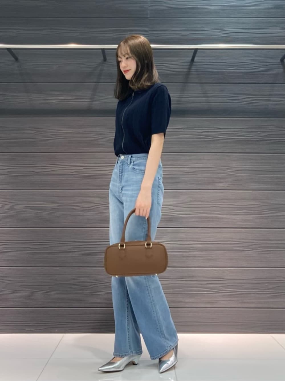 ブルー系のデニムパンツ、ブルー系のカーディガン/ボレロ、ブラウン系のボストンバッグを着用したレディースの春コーディネートの3枚目の写真